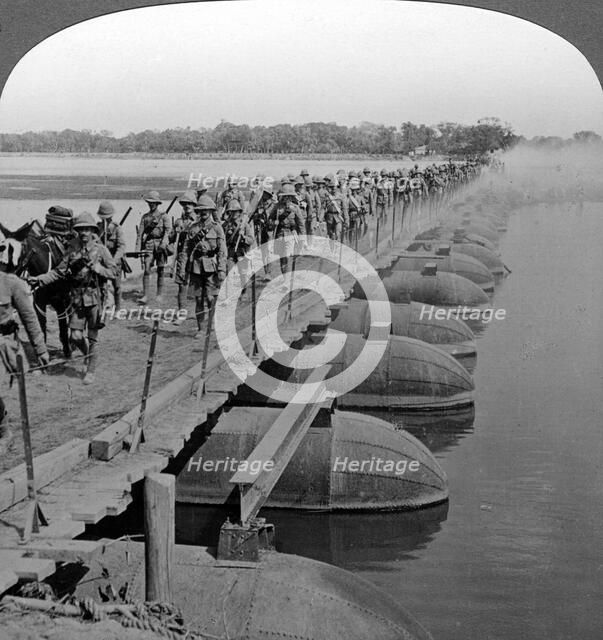 Machine gun section and infantry crossing a pontoon bridge, World War I, 1914-1918.Artist: Realistic Travels Publishers