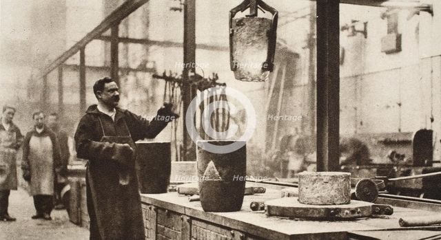 Making money; pots of liquid metal being handled in the melting room, 20th century. Artist: Unknown