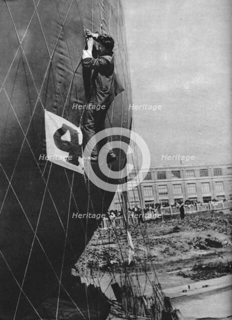 Making adjustments to the net of a balloon before attaching the basket, c1935 (c1937). Artist: Unknown.