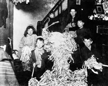 Making party streamers at home, London, c1900. Creator: Unknown