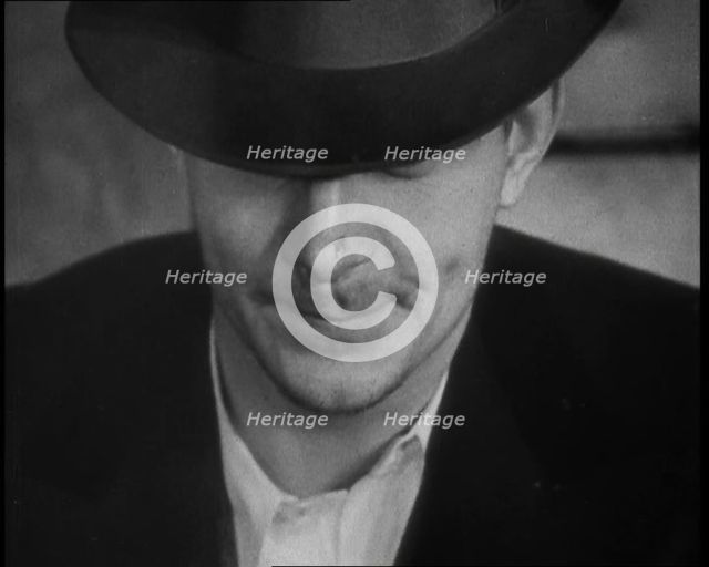 Male American Civilian Wearing a Hat Sitting at a Desk, 1930. Creator: British Pathe Ltd.