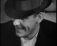 Male American Civilian Wearing a Hat Sitting at a Desk, 1930. Creator: British Pathe Ltd