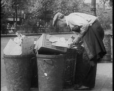 Male American Civilian Hunting Through a Rubbish Bin, 1930. Creator: British Pathe Ltd