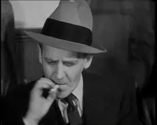 Male American Civilian Smoking a Cigarette While Reporting from the Courtroom During the..., 1930s. Creator: British Pathe Ltd