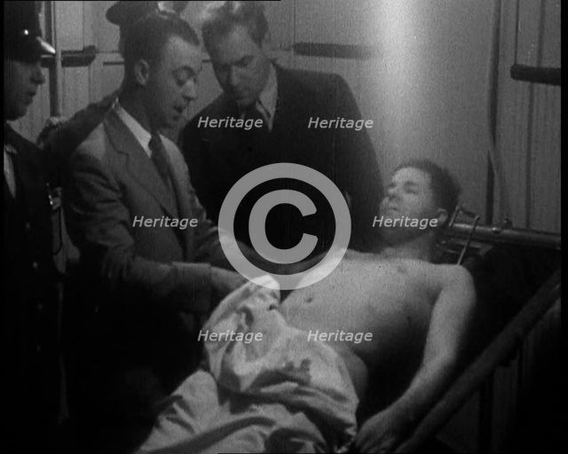 Male American Civilians Examining a Dead Body, 1930. Creator: British Pathe Ltd.