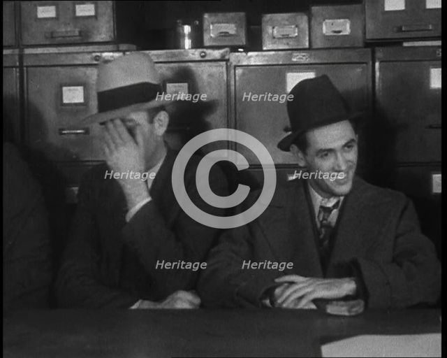 Male American Civilians Wearing Hats Sitting at a Desk, 1930. Creator: British Pathe Ltd.