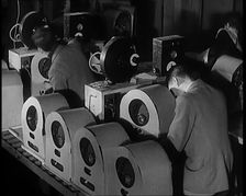 Male and Female Civilians Building Radio Wireless Sets in a Factory, 1931. Creator: British Pathe Ltd