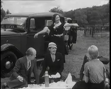 Male and Female Civilians Having a Picnic Beside a Car, 1931. Creator: British Pathe Ltd