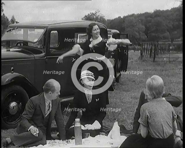 Male and Female Civilians Having a Picnic Beside a Car, 1931. Creator: British Pathe Ltd.