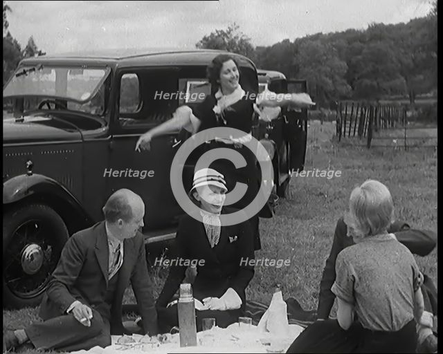 Male and Female Civilians Having a Picnic Beside a Car, 1931. Creator: British Pathe Ltd.