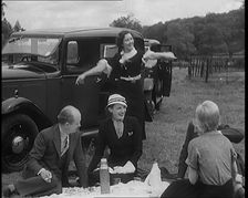 Male and Female Civilians Having a Picnic Beside a Car, 1931. Creator: British Pathe Ltd