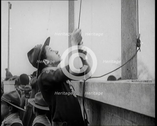 Male Boy Scout Unfurls the Flags of the British Empire, 1924. Creator: British Pathe Ltd.