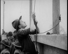 Male Boy Scout Unfurls the Flags of the British Empire, 1924. Creator: British Pathe Ltd
