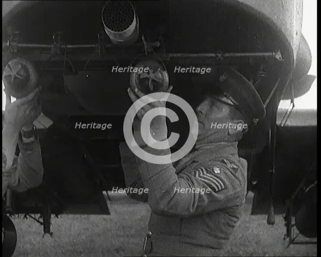 Male British Officers Mounting Bombs Into a Fighter Plane, 1920s. Creator: British Pathe Ltd.
