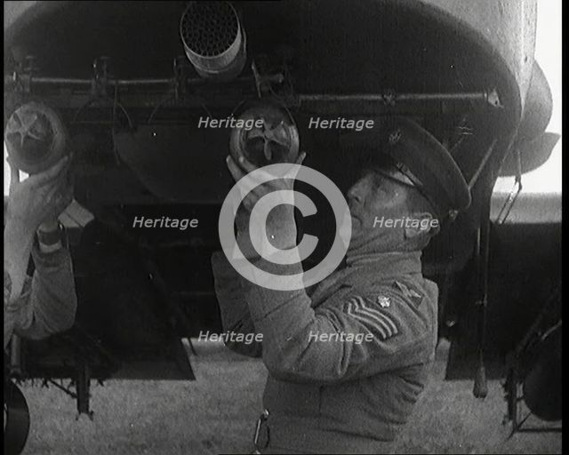 Male British Officers Mounting Bombs Into a Fighter Plane, 1920s. Creator: British Pathe Ltd.