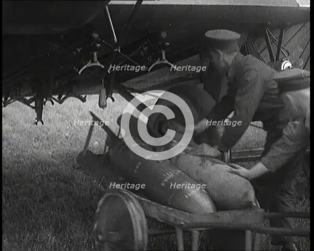 Male British Officers Loading Bombs Onto a Plane, 1920s Creator: British Pathe Ltd.