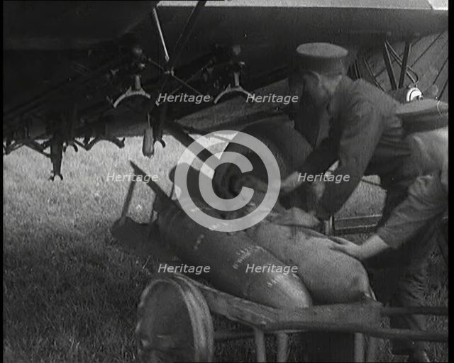 Male British Officers Loading Bombs Onto a Plane, 1920s Creator: British Pathe Ltd.