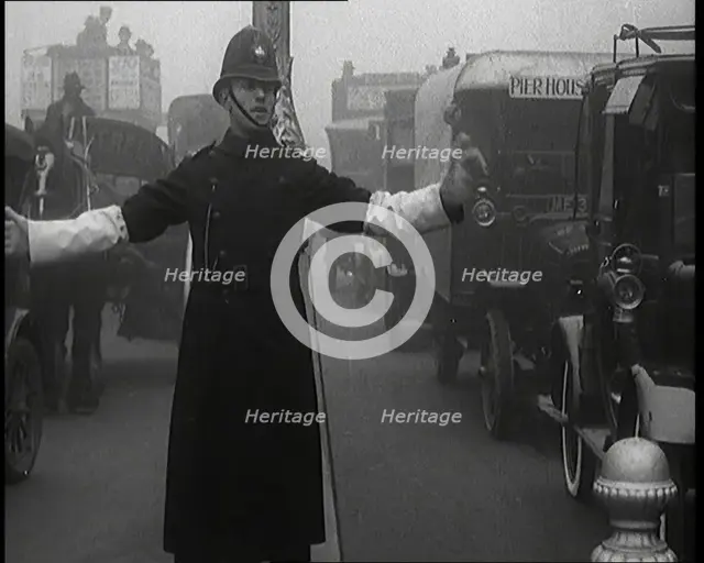 Male British Police Officer Controlling the Traffic On the Streets of London, 1920s. Creator: British Pathe Ltd.