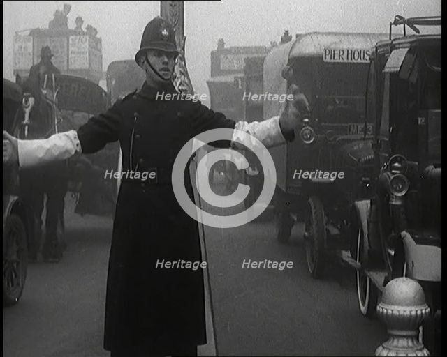 Male British Police Officer Controlling the Traffic On the Streets of London, 1920s. Creator: British Pathe Ltd.