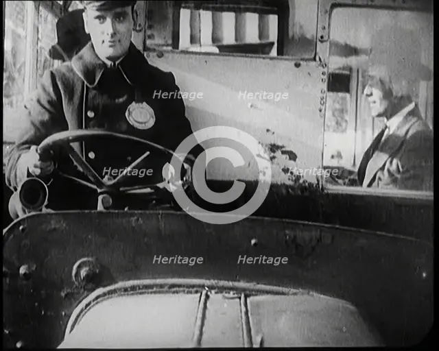Male Bus Driver Sitting in the Cabin of a Bus, 1922. Creator: British Pathe Ltd.