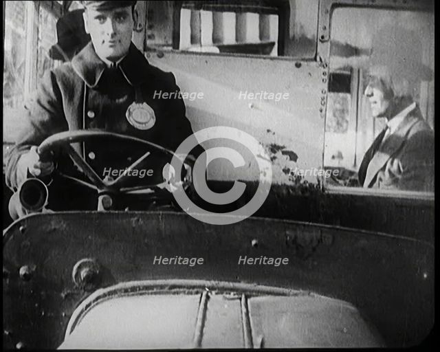 Male Bus Driver Sitting in the Cabin of a Bus, 1922. Creator: British Pathe Ltd.