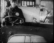 Male Bus Driver Sitting in the Cabin of a Bus, 1922. Creator: British Pathe Ltd