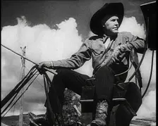 Male Civilian With a Cowboy Hat Sitting On a Coach Waiting For Passengers, 1932. Creator: British Pathe Ltd