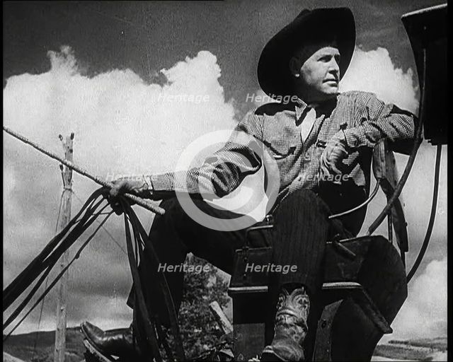 Male Civilian With a Cowboy Hat Sitting On a Coach Waiting For Passengers, 1932. Creator: British Pathe Ltd.