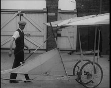Male Civilian Carrying a Small Pedal Powered Flying Machine and Trying to Demonstrate It in..., 1929 Creator: British Pathe Ltd