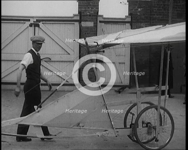 Male Civilian Carrying a Small Pedal Powered Flying Machine and Trying to Demonstrate It in..., 1929 Creator: British Pathe Ltd.