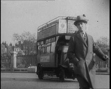 Male Civilian Crossing the Street in Front of Heavy Cars and Buses Traffic, 1920. Creator: British Pathe Ltd