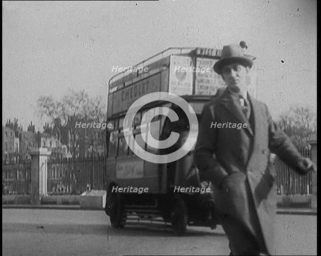 Male Civilian Crossing the Street in Front of Heavy Cars and Buses Traffic, 1920. Creator: British Pathe Ltd.