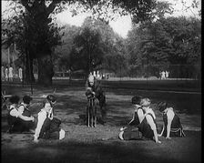 Male Civilian Demonstrating How to Set up a Cricket Wicket to a Group of Young Female..., 1920. Creator: British Pathe Ltd