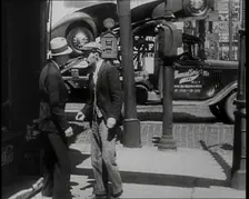 Male Civilian Stopping People On the Street Perhaps Begging or Perhaps Asking For a Job, 1932. Creator: British Pathe Ltd