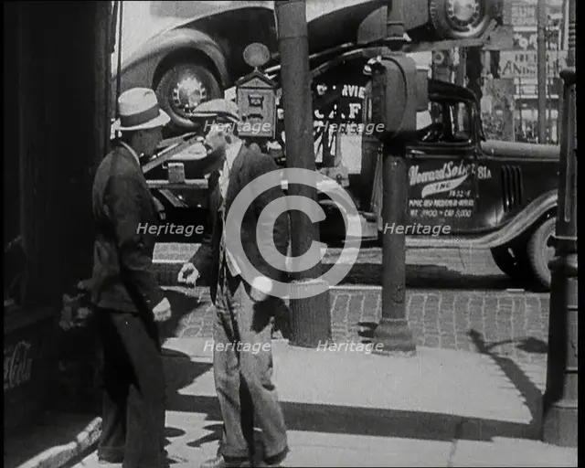 Male Civilian Stopping People On the Street Perhaps Begging or Perhaps Asking For a Job, 1932. Creator: British Pathe Ltd.