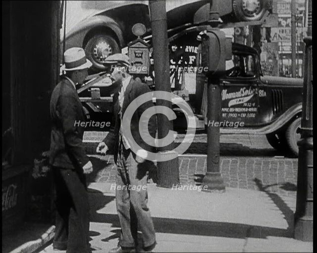 Male Civilian Stopping People On the Street Perhaps Begging or Perhaps Asking For a Job, 1932. Creator: British Pathe Ltd.