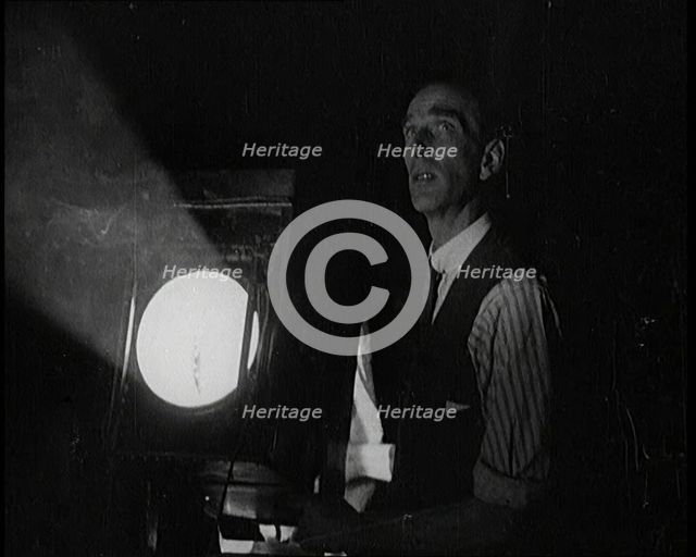 Male Civilian Stands Next to a Large Light, 1920s. Creator: British Pathe Ltd.