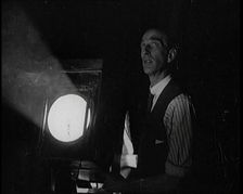 Male Civilian Stands Next to a Large Light, 1920s. Creator: British Pathe Ltd