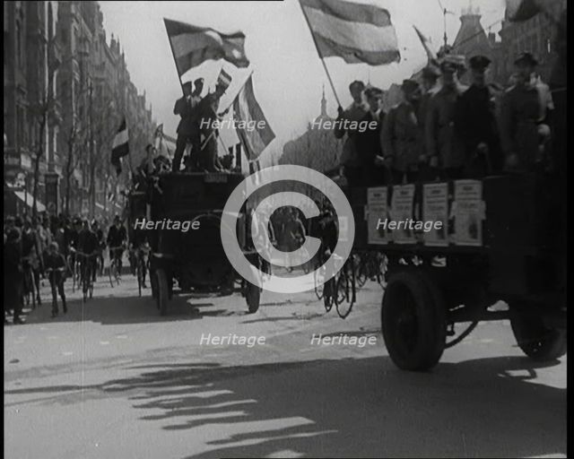 Male Civilians Driven in Trucks Parade Waving Flags. Other Male Civilians Ride Alongside on..., 1924 Creator: British Pathe Ltd.
