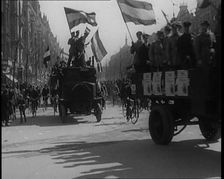 Male Civilians Driven in Trucks Parade Waving Flags. Other Male Civilians Ride Alongside on..., 1924 Creator: British Pathe Ltd