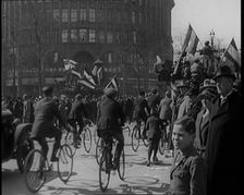 Male Civilians Driven in Trucks Parade Waving Flags. Other Male Civilians Ride Alongside on..., 1924 Creator: British Pathe Ltd