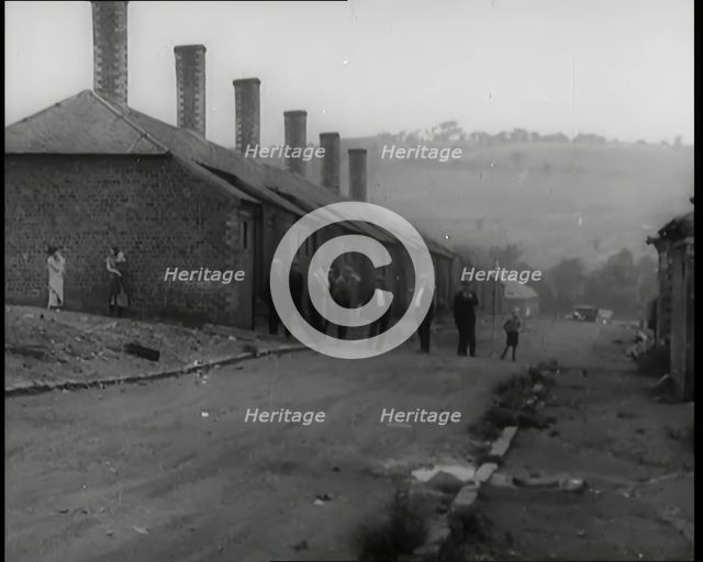 Male Civilians Standing in the Streets Outside of Their Houses, 1926. Creator: British Pathe Ltd.