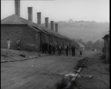 Male Civilians Standing in the Streets Outside of Their Houses, 1926. Creator: British Pathe Ltd