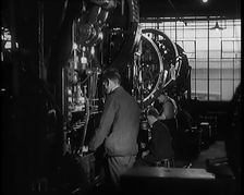 Male Civilians Working Large Presses in a Factory, 1931. Creator: British Pathe Ltd