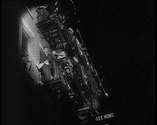 Male Civilians Watching a Female Civilian in Traditional Robe Performing With Sabres..., 1932. Creator: British Pathe Ltd