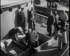 Male Civilians Unloading Illegal Cargo from a Boat, 1932. Creator: British Pathe Ltd