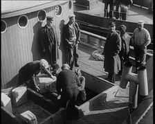 Male Civilians Unloading Illegal Cargo from a Boat, 1932. Creator: British Pathe Ltd