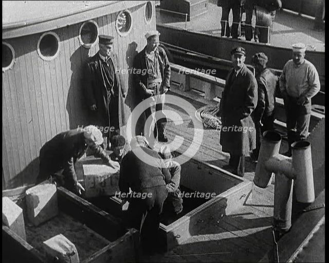 Male Civilians Unloading Illegal Cargo from a Boat, 1932. Creator: British Pathe Ltd.