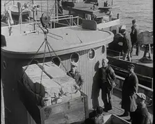 Male Civilians Unloading Illegal Cargo from a Boat, 1932. Creator: British Pathe Ltd