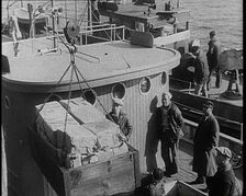 Male Civilians Unloading Illegal Cargo from a Boat, 1932. Creator: British Pathe Ltd